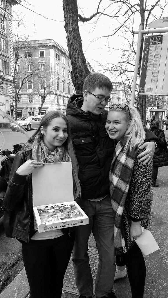 Čierno biela fotografia ako stojíme ja, Bazi a Domi na ulici a ja držím otvorenú krabicu s pizzou