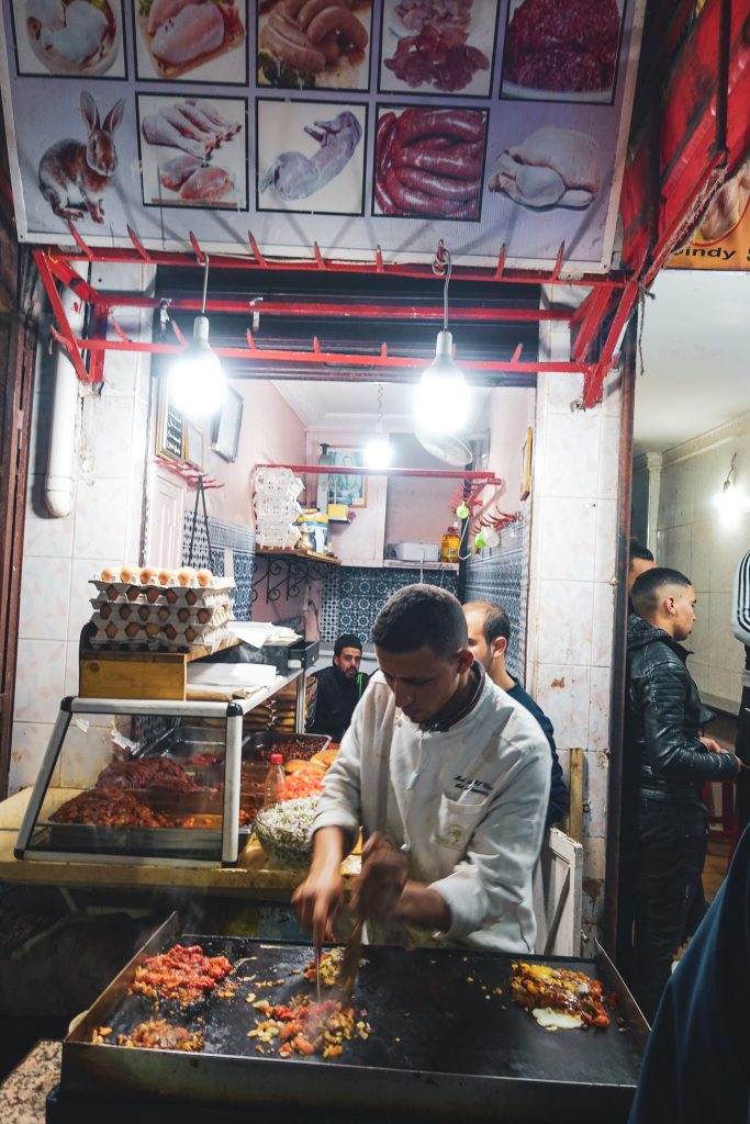 Maročan pripravujúci jedlo na veľkej grilovacej platni
