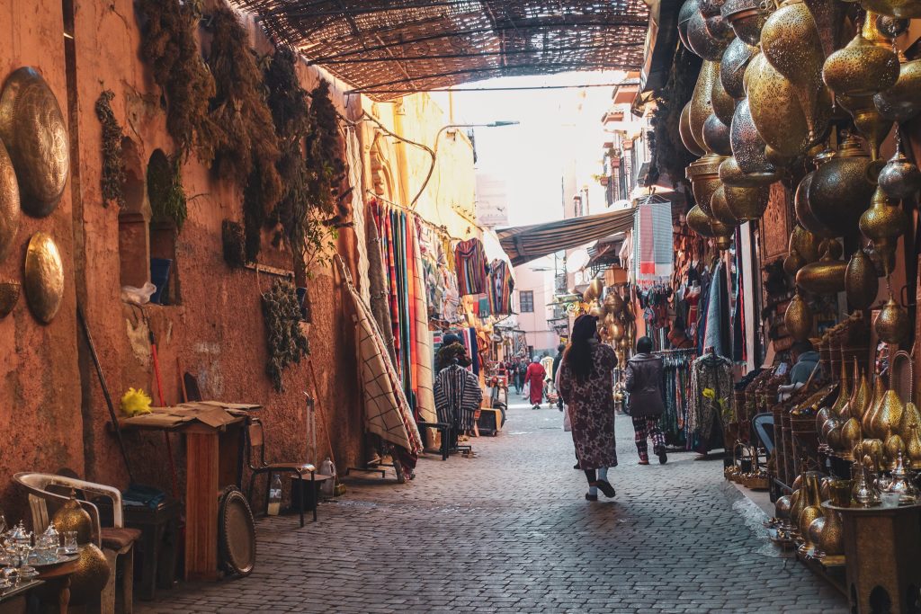 Ulička v Medine, kde je vidieť viacero lámp, sušených byliniek, kobercov a iných vecí na predaj