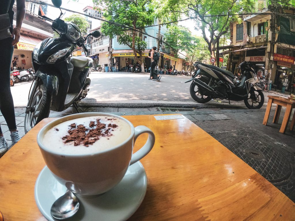 Šálka vietnamskej vaječnej kávy v pozadí ulica