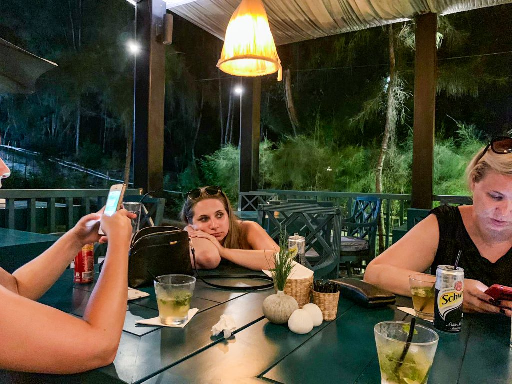 Sedíme v hotelovom bare na terase, Miška a Domi si ťukajú do telefónu, ja smutne ležím na stole a pozerám do neurčita. Pred nami na stole sú drinky