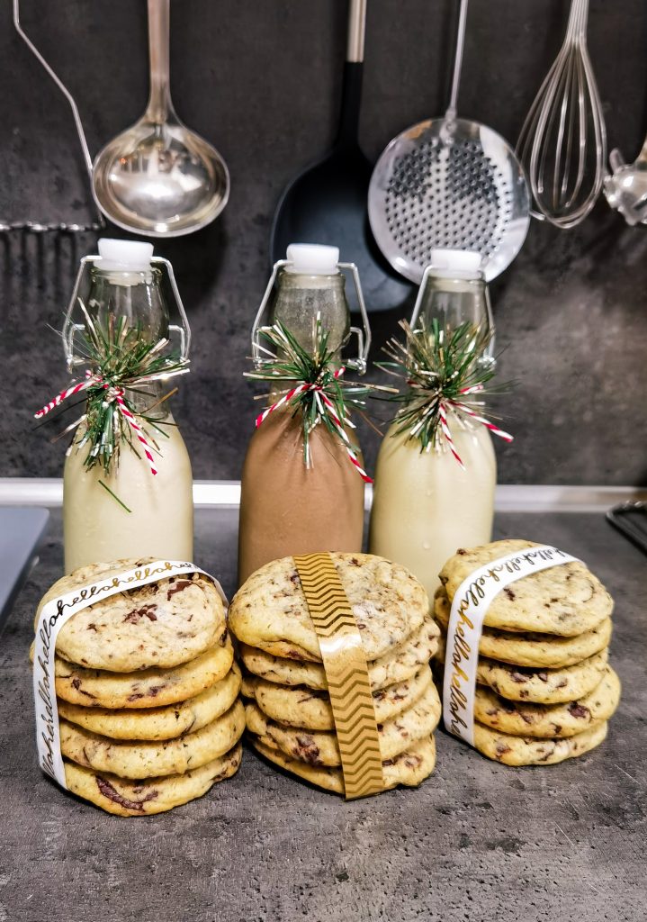 Vianočne ozdobené fľaše vaječného koňaku so zabalenými čokoládovými cookies