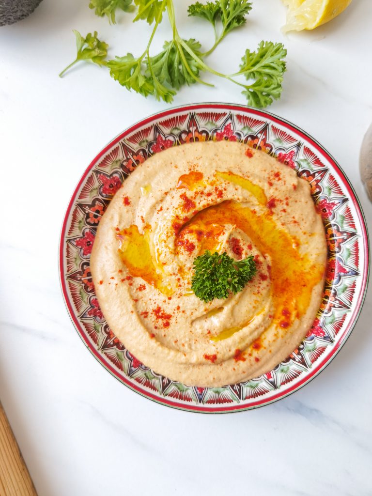 harissa hummus v miske preliaty olejom a posypaný červenou paprikou