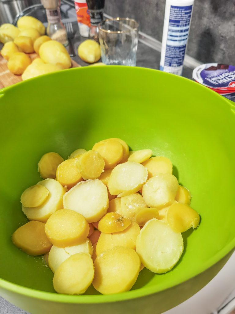 Plátky uvarených zemiakov v zelenej mise