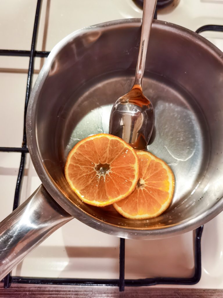 dva plátky pomaranču, voda a, med a lyžica v hrnci