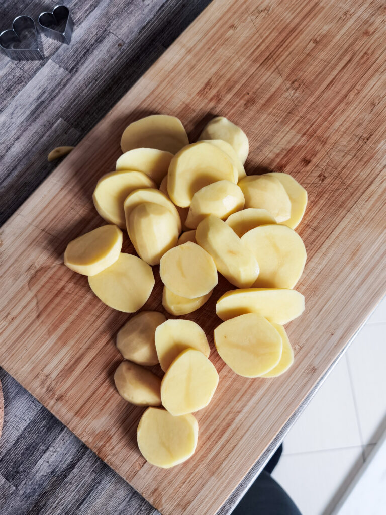 viacero plátkov zemiakov na krájacej doske