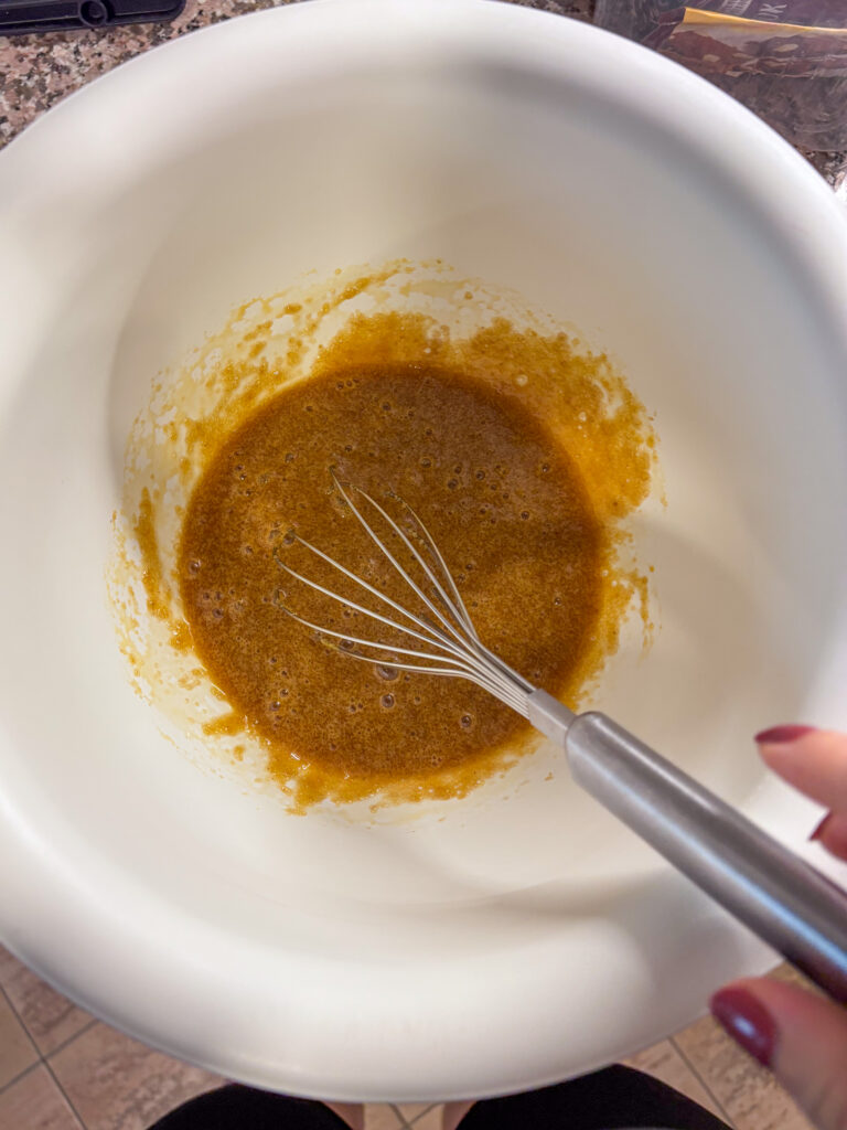 rozmiešané vajcia s cukrom a s metličkou v ruke